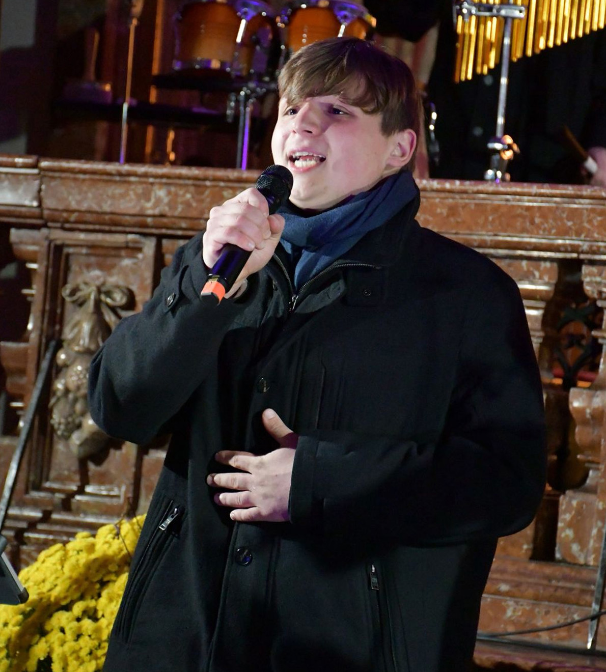 Tenor mit Mikrofon bei einem emotionalen Live-Auftritt in der Kirche